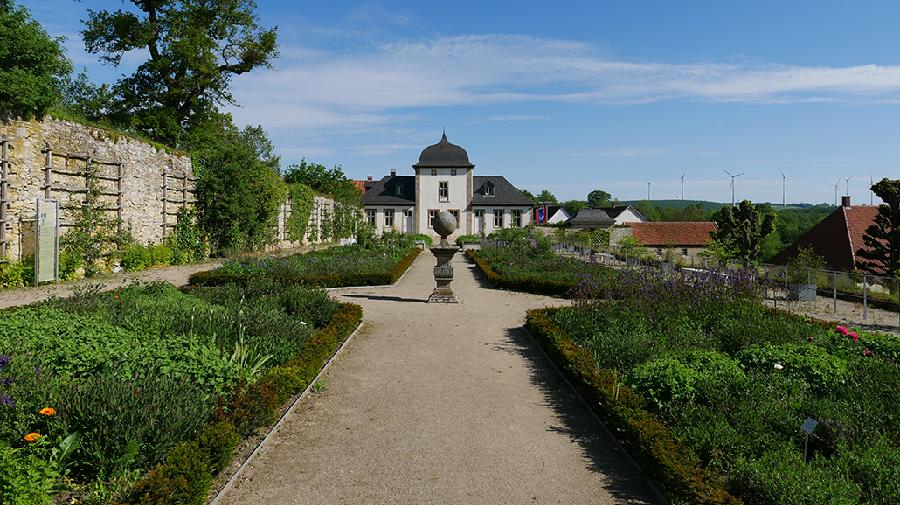 Der lange Garten des Klosters mit grünen Beeten. 