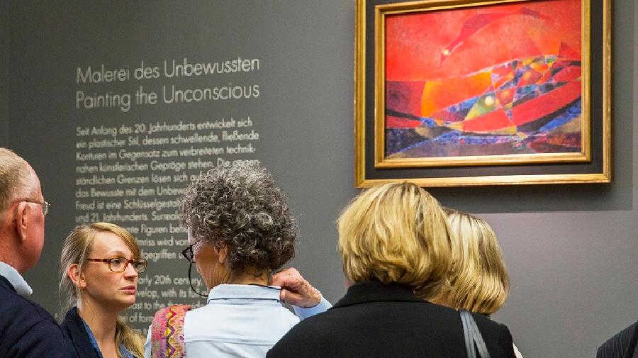 Menschen vor Gemälde von Max Ernst