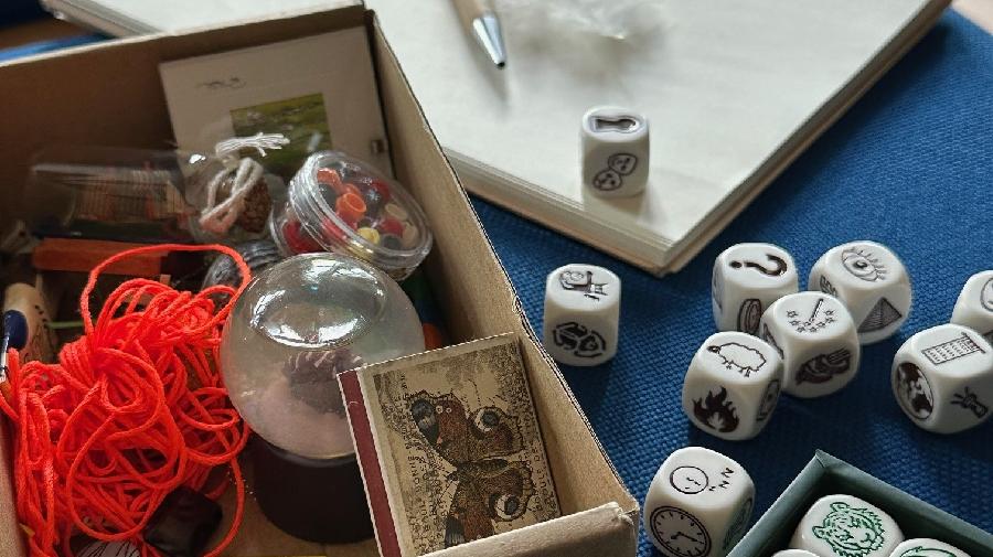 Verschiedene Materialien und Objekte auf einem Tisch. Darunter Würfel und Block.