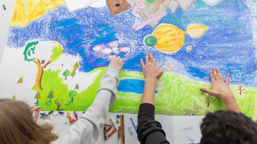 Zwei Kinder malen ein Bild.