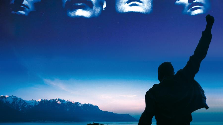 Umriss eines Mannes mit hoch gereckter Faust vor einem See, am Himmel die Köpfe der vier Musiker.