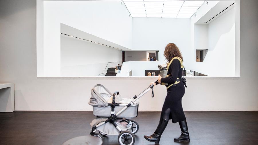 Eine Frau mit Kinderwagen im Museum.