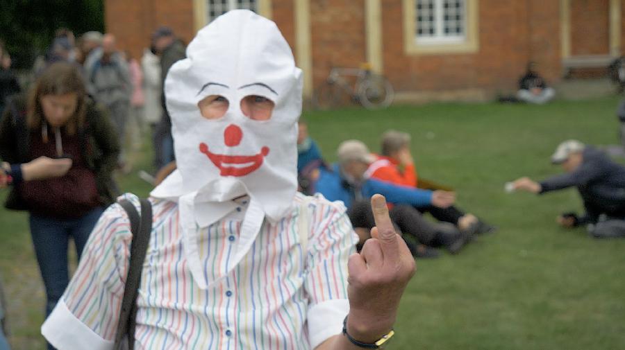 Eine Filmszene aus einem Werk von Zauri Matikashvili. Ein Mann mit Clownsmaske blickt in die Kamera.