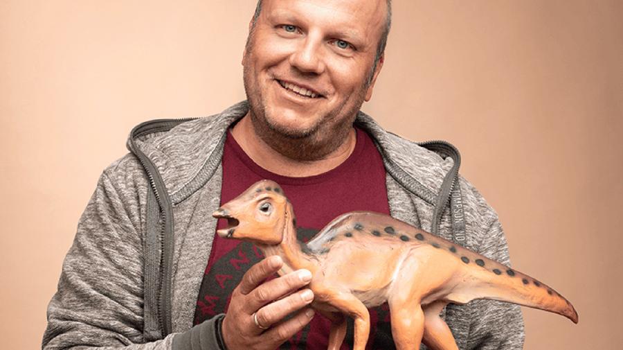 Stefan Schröder mit einem Modell eines Dinosauriers.