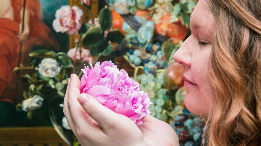 Eine Frau riecht an einer Blume