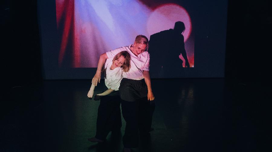 Zwei Frauen auf der Bühne bei einer Performance.