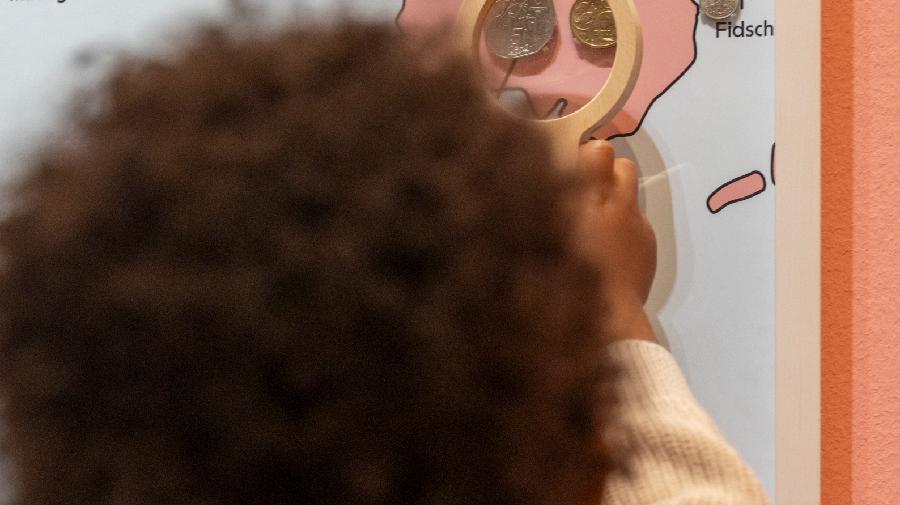 Ein Junge erkundet eine Landkarte mit einer Lupe