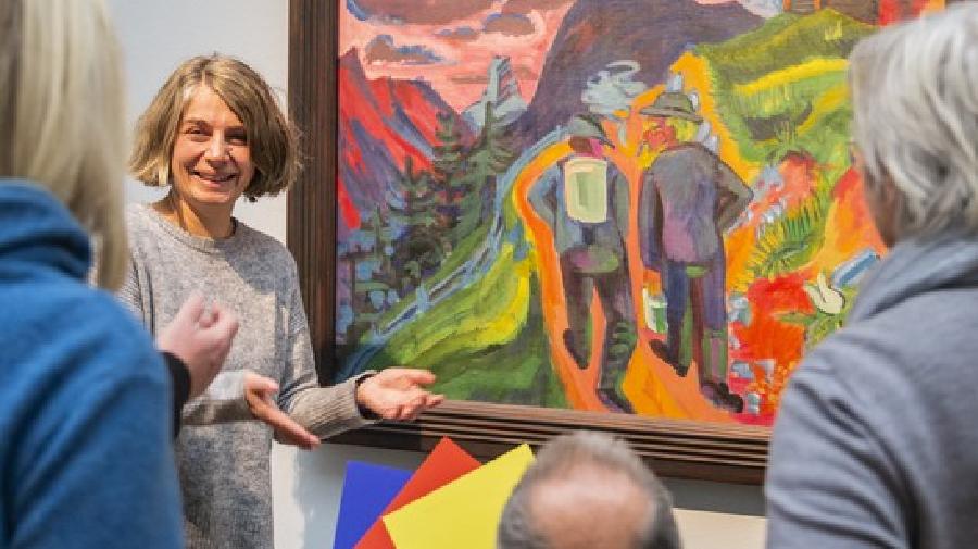 Eine Gruppe von Personen unterhält sich vor Kunst. 