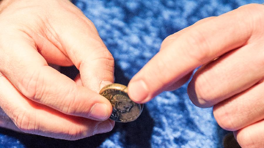 Hände berühren eine Münze