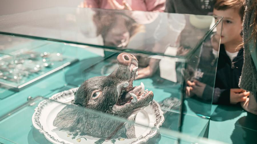 Vitrine mit Wildschwein-Terrine und Besuchenden, Bild: Malte Hömberg