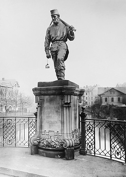 Denkmal eines Bergmannes von Friedrich Reusch (*1843 +1906), aufgestellt 1904 auf der Nordseite der Siegbrücke, Modell stand: Philipp Hüttenhain, Seelbach, Inschrift: "Wer Bergwerk will bauen, muss Gott vertrauen"