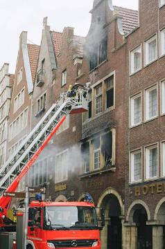 Feuerwehrmann im Einsatz auf der Drehleiter: Brand in der Feinkosthandlung "Holstein", Bogenstraße