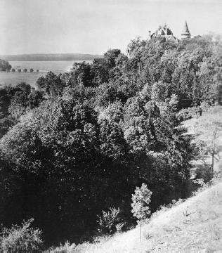 Blick über bewachsene Hügel auf Burg Calenberg
