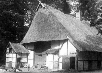 Altes Fachwerk-Bauernhaus mit Giebelzier und Stockwalmdach aus Stroh (Dreiständerbau)