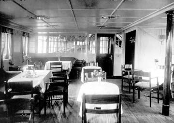 Café auf dem seitlich geschlossenen Promenadendeck des Seebäderdampfers "Roland" der Reederei Norddeutscher Lloyd