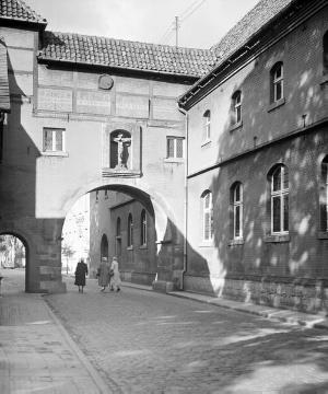 Wiedenbrück, Mönchstraße, nach 1948: Der Klosterbogen, erbaut 1645 als Verbindung zwischen Franziskanerkloster (gegr. um 1644) und St. Ursula-Kirche, ehem. St. Marien (der Durchgang für Fußgänger neben der Durchfahrt wurde erst 1948 erstellt)