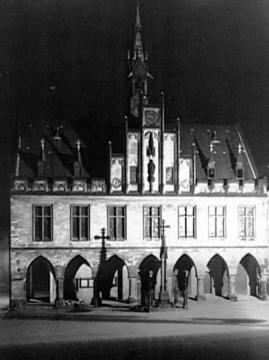 Rathaus bei Nacht mit dem Marktkreuz aus Sandstein