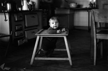 Kind im Laufwagen in der Küche