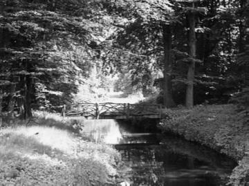 Bach mit Holzbrücke im Schlosspark