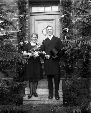 Hochzeit B. Hidding und Maria Tünte, Brautpaar vor dem Eingang des Hauses - undatiert, Ende 1920er Jahre?