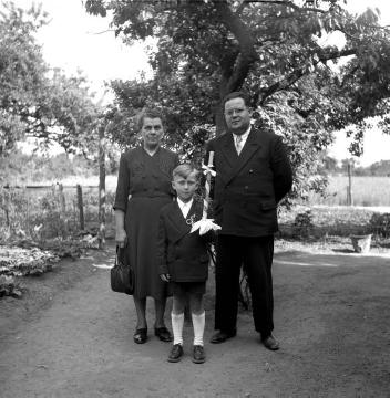 Kommunionkind Berni Funke, Weseler Straße 43, mit Paten Anna Funke (geb. Gudel) aus Gelsenkirchen-Bismarck, und Willi Bolte aus Dorsten