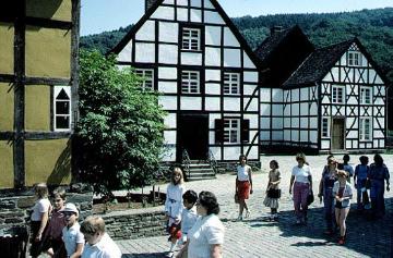 LWL-Freilichtmuseum Hagen: Besuchergruppe zwischen Goldschmiede und Kürschnerei