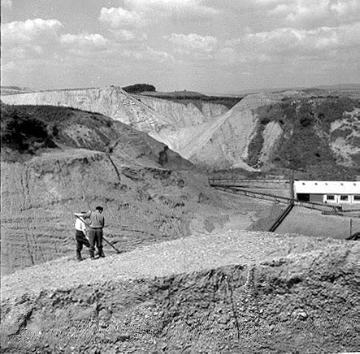 Arbeiter am Rand der Kiesgrube bei Möllenbeck mit Blick in die Grube