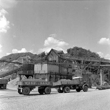Lastwagen mit Kies vor einem Werksgebäude an der Kiesgrube bei Möllenbeck