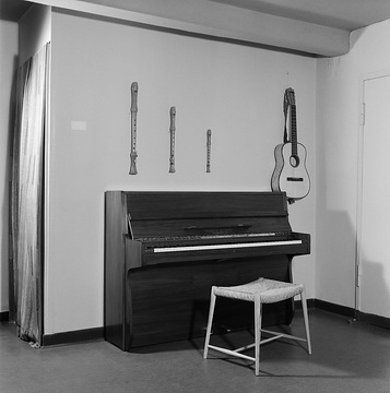 Ausstellung Modernes Wohnen, 1961: Klavier mit Hocker, Gitarre und drei Blockflöten an der Wand