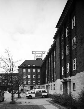 Polizeipräsidium von 1929: Frontpartie in der Schrägansicht, Baudenkmal (Uhlandstraße 35), im Hintergrund: Förderturm des Bergbaumuseums