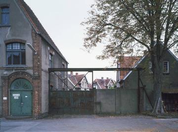 Werkstor der Textilfabrik Kümpers mit Blick in die Werkssiedlung Heidhoevelstraße