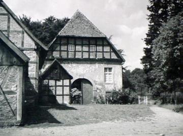 Altes zweigeschossiges Bauernhaus mit Walmdach und Fachwerk im oberen Geschoß (bei Füchtorf)