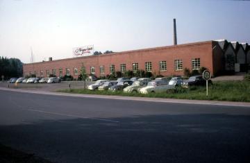 Textilindustrie in Greven, 1964: Weberei Cramer, Werksgebäude mit Parkplatz