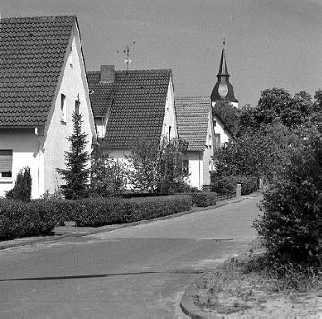 Straße mit Wohngebäuden in Levern mit Blick zur ev. Pfarrkirche
