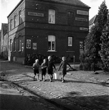 Vier Jungen beim Gang durch das Dorf, im Hintergrund die Drogerie Schwar