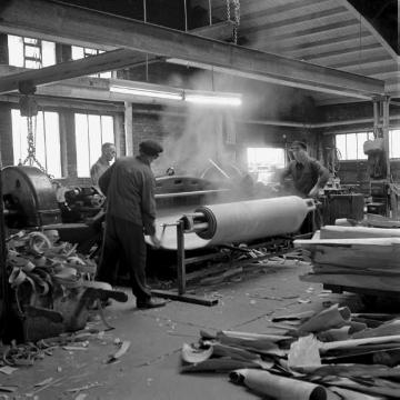 Brakeler Gewerbebetrieb: Holzaufbereitung an der Schälmaschine einer Sperrholzfabrik