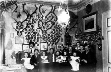 Förstei Obereimer, Weihnachten 1910: Försterfamilie Goebel und Verwandte im Jagdzimmer vor einer stattlichen Trophäenwand