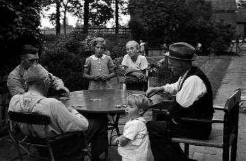 Kartenspieler auf dem Hof Böckenhoff mit Josef und Bernhard Böckenhoff, Hinten am Tisch: (links)
Friede Büsken und (rechts) Margret Nießing