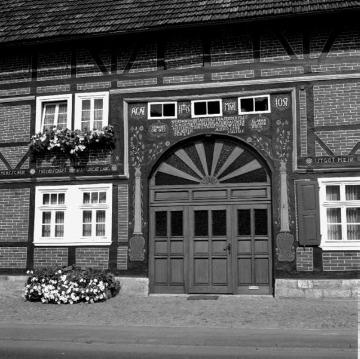 Marienmünster-Bredenborn, 1976: Wohngebäude Höxter Straße 9, erbaut 1798 in Backstein-Fachwerk - Eingangstor mit der Inschrift "Johannes Drewes / wer da wohnet an der Straßen / der mus sich ofter thadeln lasen / dan mer heite mit dir ist / kan morge wieder dich sein / Anno 1798".