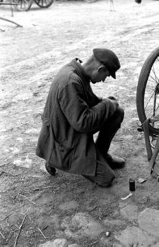 Junger polnischer Kriegsgefangener beim Fahrrad flicken. Raesfeld, 1940.
