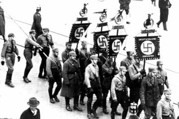 Mitglieder der Nationalsozialistischen Deutschen Arbeiterpartei (NSDAP) auf dem Weg zur Ersten Parteitagsversammlung auf dem Marsfeld in München 1921