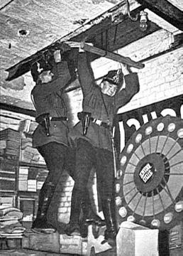 Zwei Schutzpolizisten bei der Durchsuchung des Karl-Liebknecht-Hauses in Berlin, Zentrale der Kommunistischen Partei Deutschlands im Februar 1933