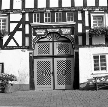 Eingangstür eines Fachwerk-Bauernhauses aus dem 18. Jahrhundert im Dorf Kirchveischede