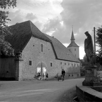 In Vinsebeck: Gutsscheune mit Blick auf die Pfarrkirche Johannes der Täufer und eine Brückenskulptur des Hl. Nepomuk