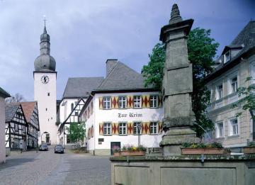 Oberstadt, Alter Markt: Der Maximiliansbrunnen, errichtet 1779, mit Glockenturm der kath. Stadtkapelle St. Georg, eingeweiht 1323