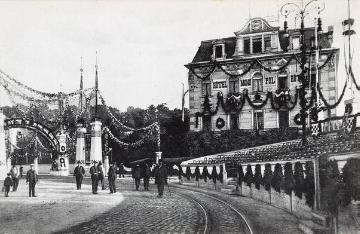 "Kaisertage" in Münster, 1907: Festlich geschmückter Servatiiplatz anlässlich des Besuches Kaiser Wilhelms II. Im Hintergrund: Hotel Monopol. [Postkarte, Verlag J. Stehr & R. Knuffmann, Krefeld]
