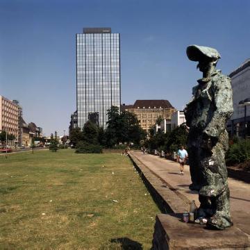 Dortmunder Königswall mit "Hüttenmann"-Denkmal, später transloziert auf den Phoenix-Platz am Phoenix-Stahlwerk West in Dortmund-Hörde. Im Hintergrund: ehemaliger Feme.