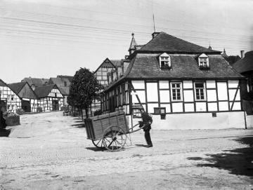 Fachwerkviertel in Warstein: Ackerbürgerhäuser und alte Schule - im Vordergrund: Postbote mit Paketwagen, um 1930?