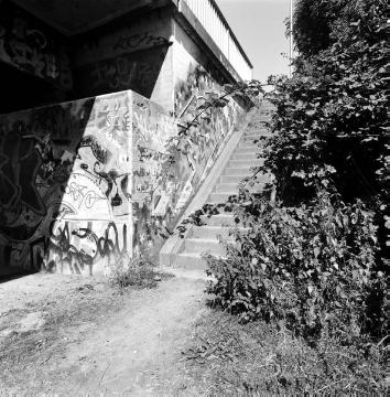 Am Dortmund-Ems-Kanal, Westufer: Graffiti-Malerei am Treppenaufgang zur Laerer Landweg-Brücke und Manfred von Richthofen-Straße