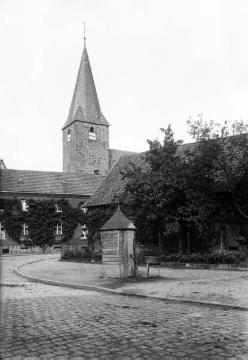 Dorsten-Lembeck 1918, Straßenkreuzung Wulfener Straße / Bahnhofstraße mit Blick auf den Turm der kath. St. Laurentius-Kirche. Im Vordergrund: Dorfbrunnen in gemauertem Häuschen, in den 1960er Jahren abgebrochen.